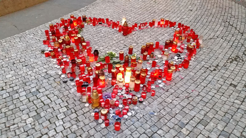 candles on cobbled pavement in the shape of a heart