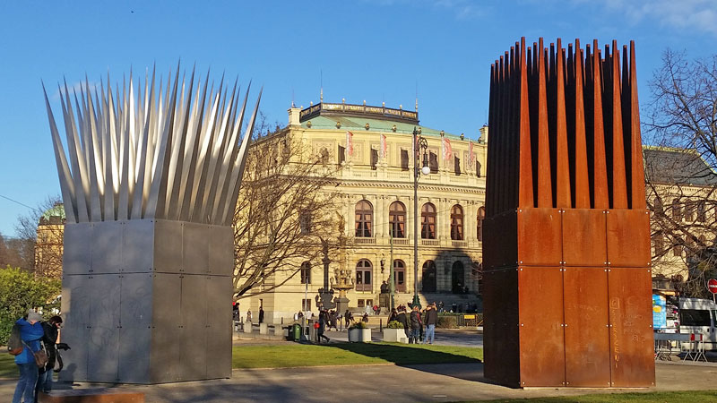 two metal structures both 2.8 metres square and both with spikes on the top. one on the left is made from stainless steel and the one on the right from weathering steel