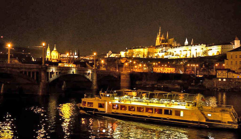 tour boat on the river vltava at night with prague castle lit in background