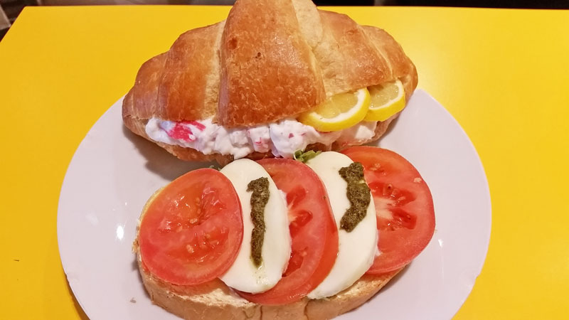 a croissant filled with crab cocktail and an open czech chlebicky sandwich with caprese