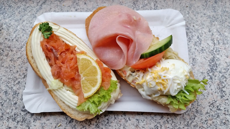 two czech open sandwiches known as chlebicky, one with ham and half a boiled egg, the other with smoked salmon and mayonnaise