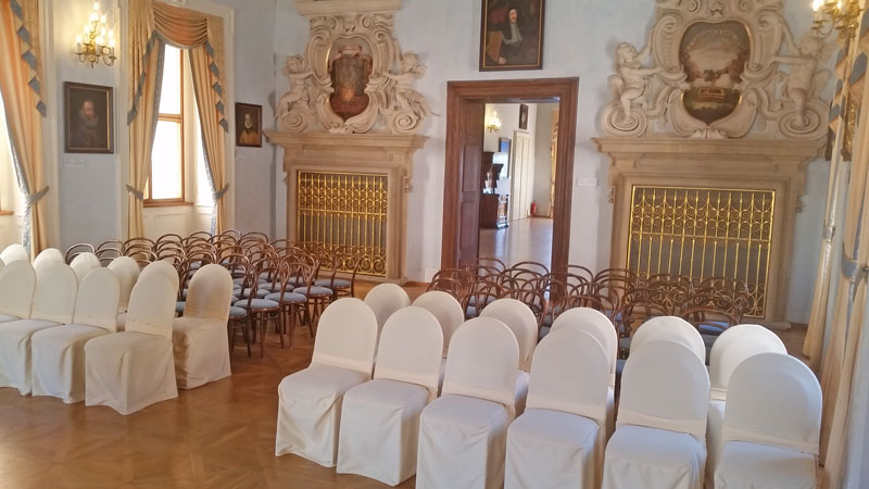 prague lobkowicz palace concert room with covered chairs and stuccoed wall details