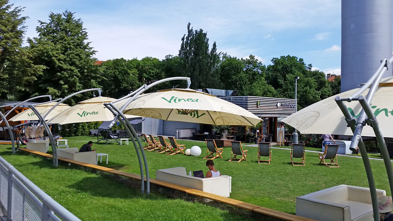 prague tower park and miminoo restaurant with large umbrellas and deckchairs on a lawn