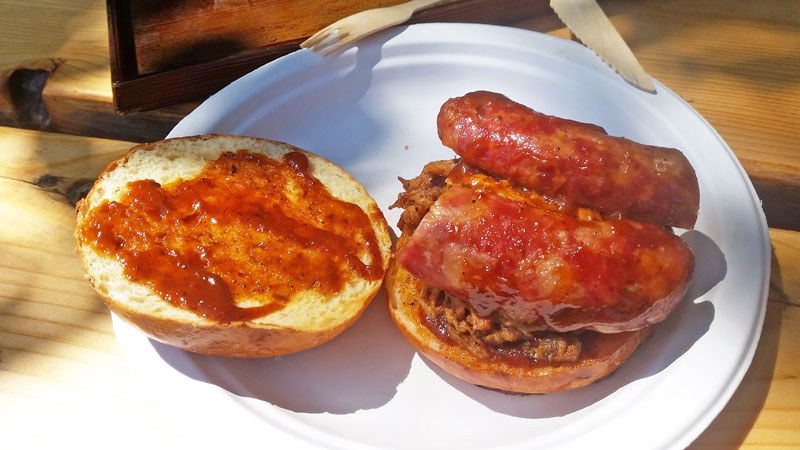 Brioche bun from bobs bbq with pulled pork and a homemade sausage mixed with a bbq sauce, served on a paper plate. called a sloppy joe sandwich