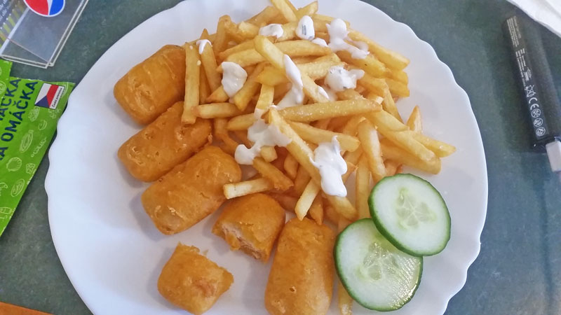 5 fried salmon nuggets served with chips, tartar sauce and two slices of cucumber