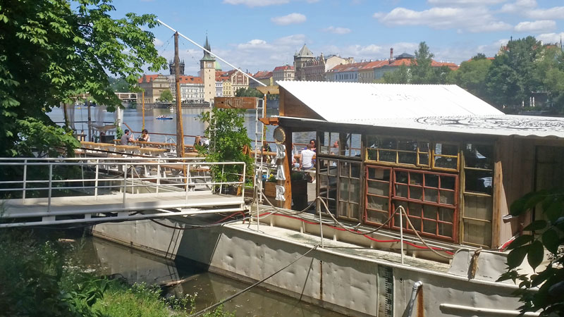 white restaurant barge moored on the river next to shooters island in prague