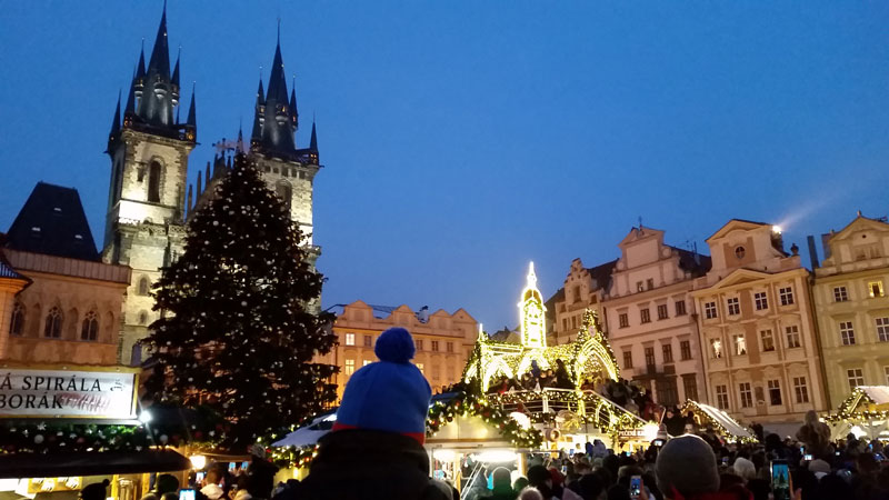 crowd of people on prague old town square waiting for the christmas tree to be lit