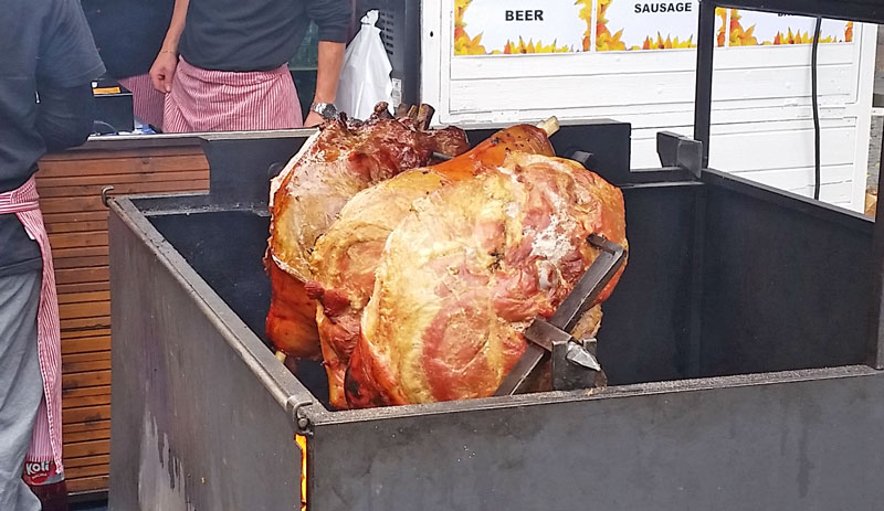 3 old prague ham joints cooking on a spit