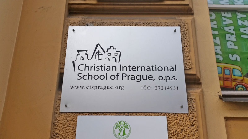 metal sign on a wall saying christian international school of prague