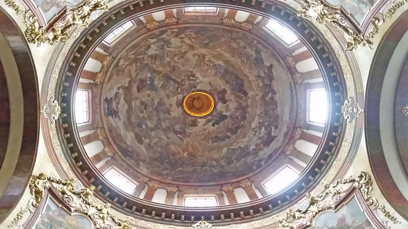 cuppola of st francis church in prague with frescoed ceiling and windows in the dome