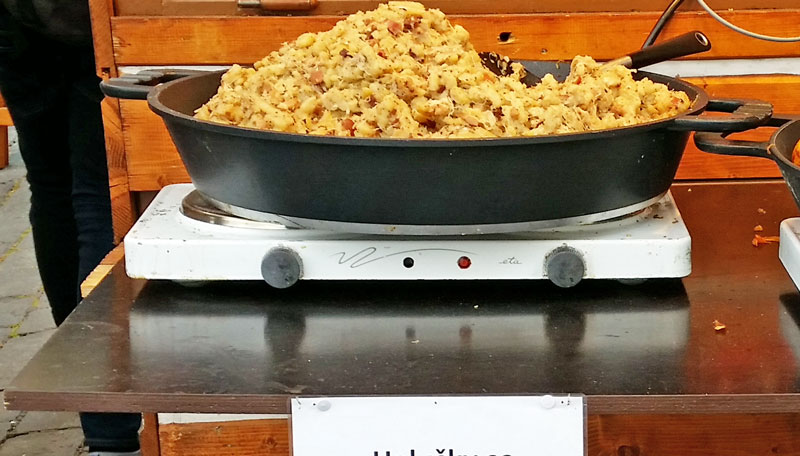 bowl of pre-mixed halusky in an iron skillet on on electric hob