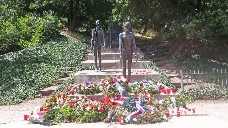 monument to victims of communism in Prague lesser town, stone steps with bronze figures, wreaths and flowers