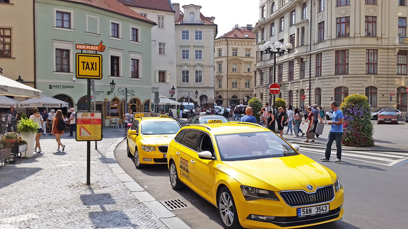 two yellow prague taxis parked at a fair place zone