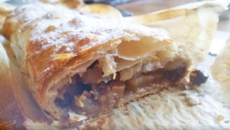 homemade apple strudel cut open on baking paper