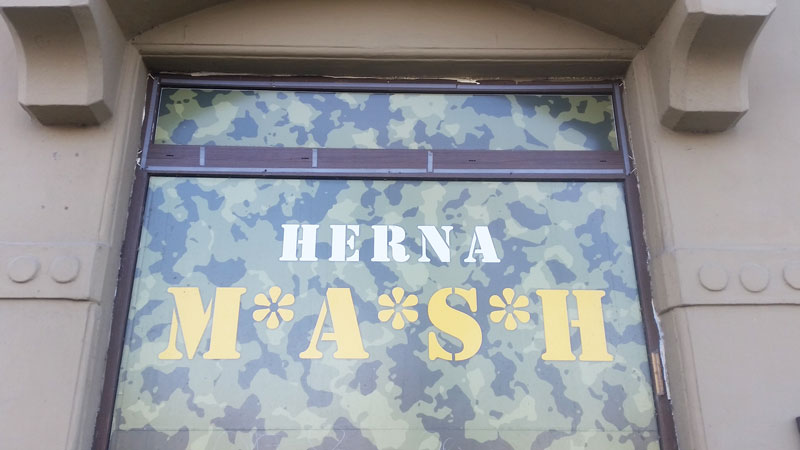 prague herna bars camouflage patterned window with the words herna m-a-s-h