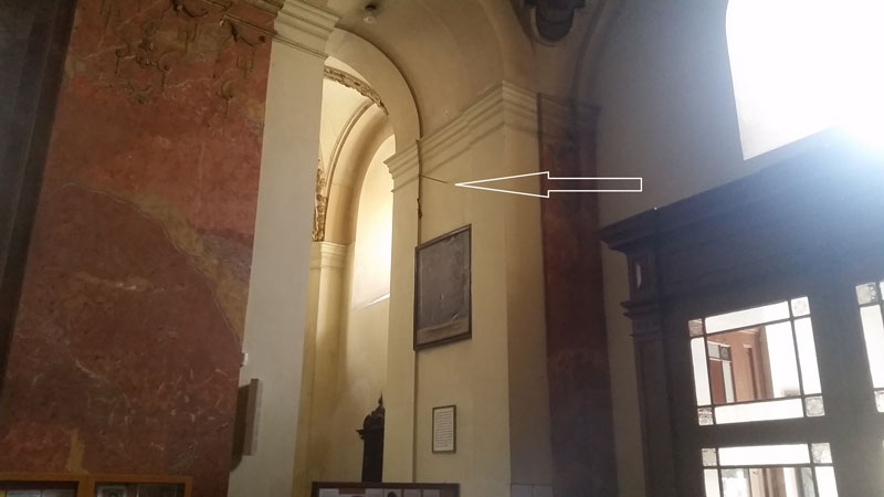 st james basilica entry with arrow pointing to the location of an arm bone hanging from a chain