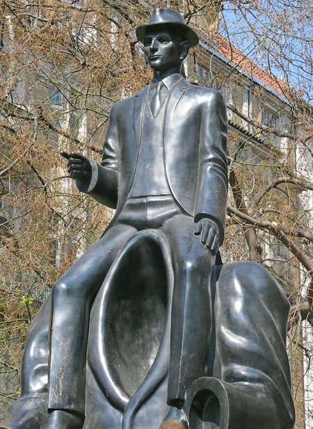 the franz kafka bronze monument in prague with him sitting on the shoulders of an empty jacket