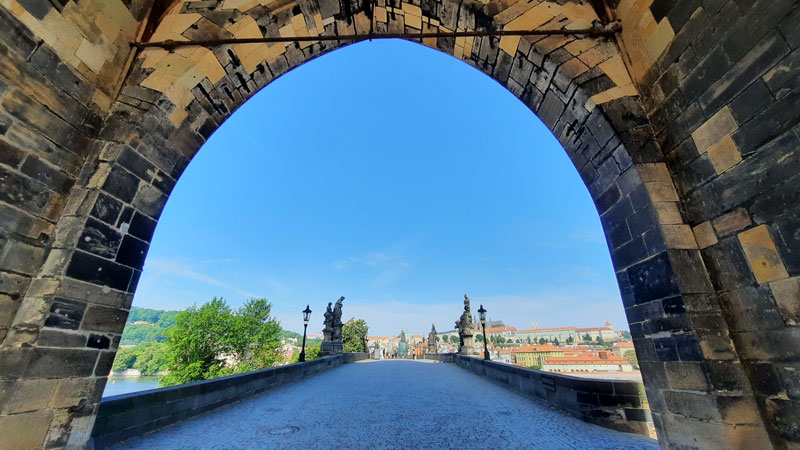 prague charles bridge scene view from under the old town gate tower showing an almost empty bridge