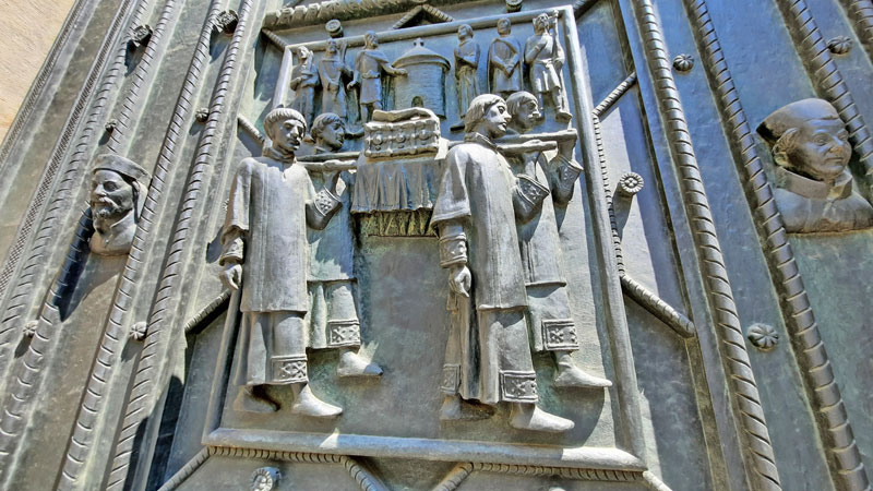 bronze detail on a st vitus cathedral door showing the relics of st vitus being carried to the new rotunda