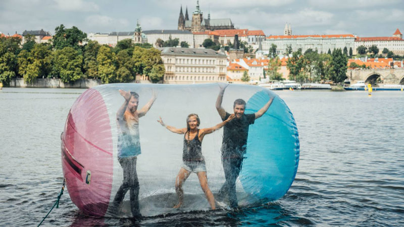 three people water zorbing in prague with the castle in the background