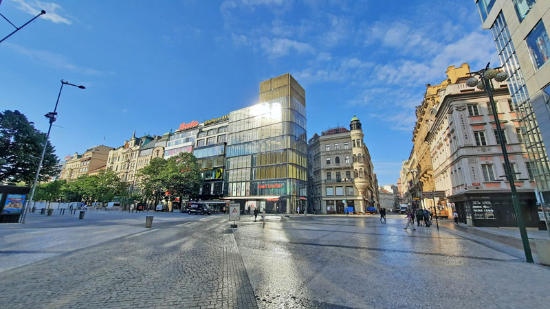 bottom part of prague wenceslas square in the morning with sun reflecting from windows onto cobbles