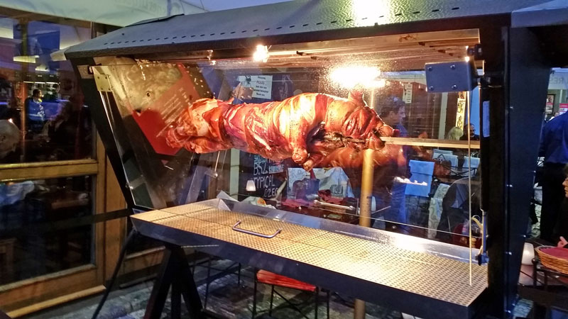 prague suckling pig roasting on a spit