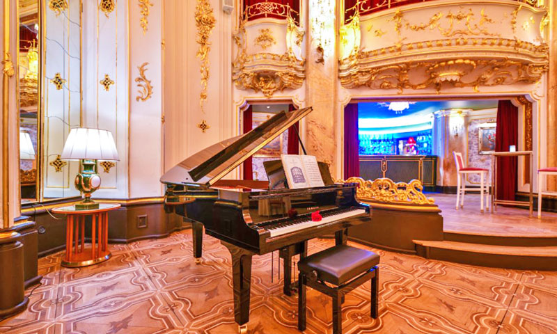 a grand piano in the boccaccio ballroom on a beautiful hardwood inlaid floor and baroque style decor
