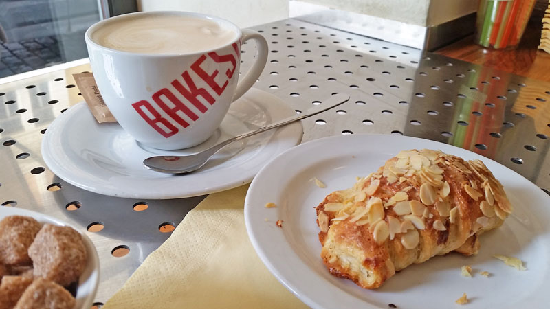 bakeshop praha cup of coffee and next to it a plate with a sweet pastry