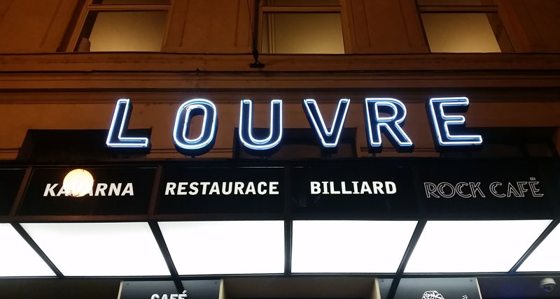 cafe louvre sign lit at night