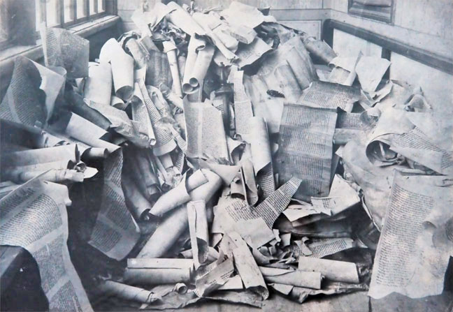 black and white photo of jewish torah scrolls in a pile at the michle synagogue in prague