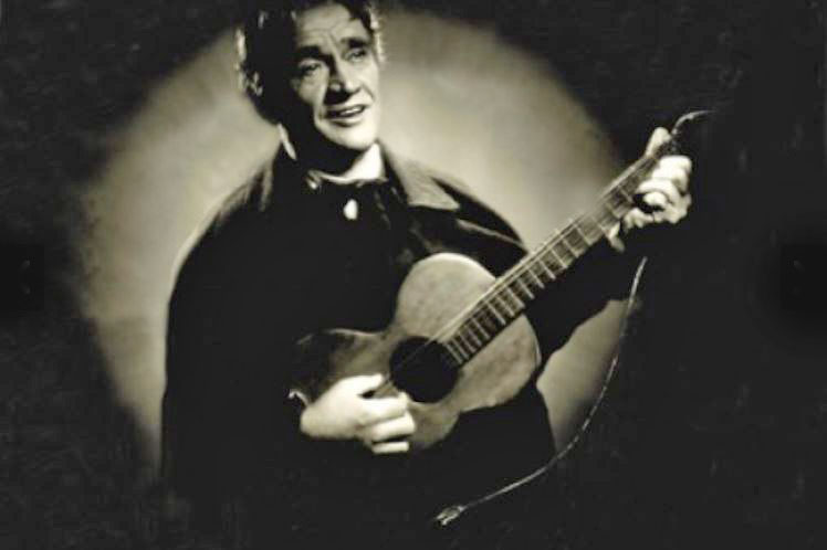 Karel Hašler playing guitar in a black and white film