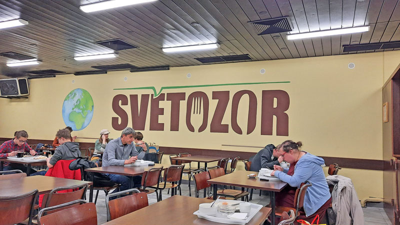 people sitting at tables in the svetozor jidelna in prague