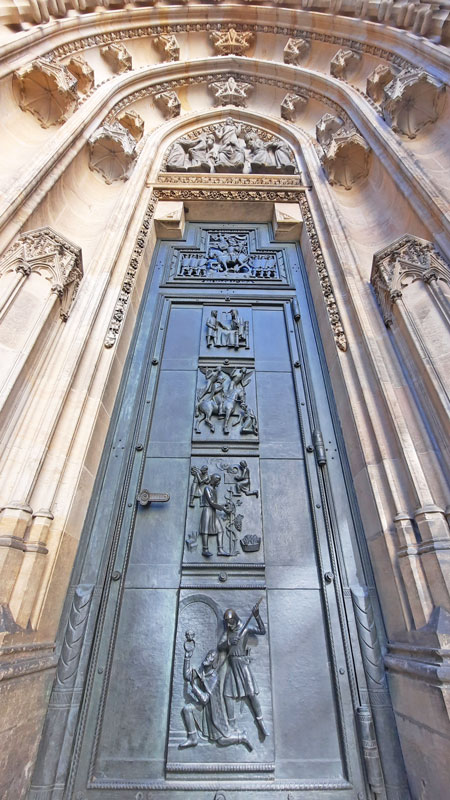 vertical picture of prague st vitus cathedral right hand door showing scenes from the life of st wenceslas