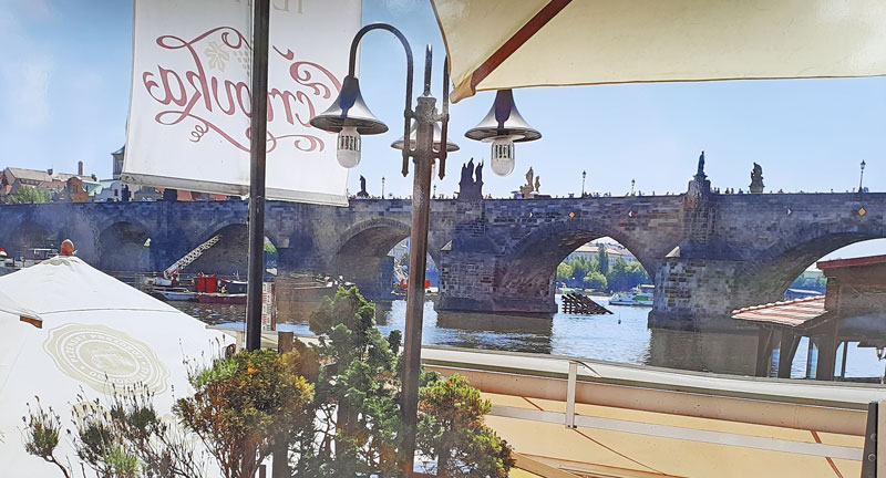 scenic view of charles bridge in prague from the riverside restaurant certovka