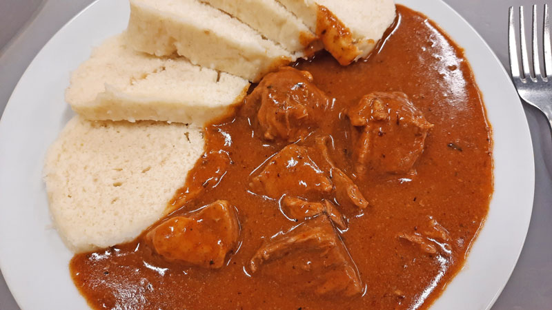 Prague Goulash - Beef on a white plate with fork