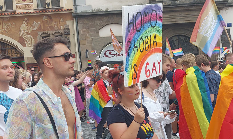 Prague Pride Parade Passing Through the Old Town Square with rainbow flags and signage