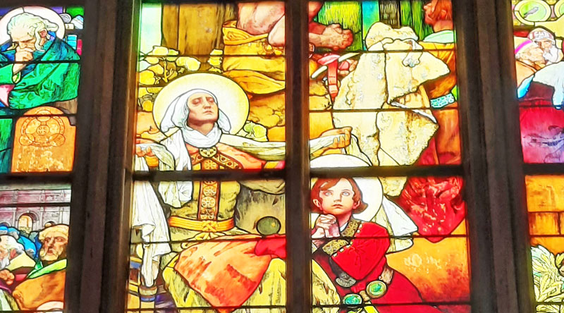 detail of a stained glass window in prague st vitus cathedral by alfons mucha