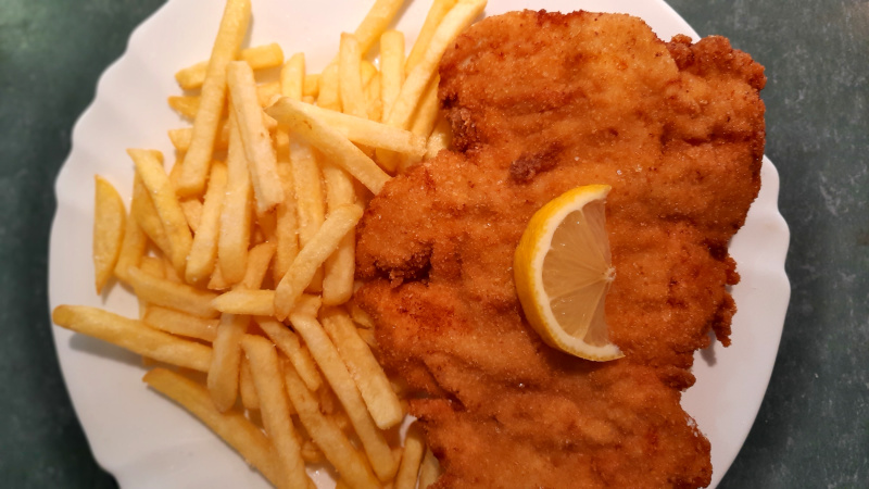 fried chicken schnitzel with slice of lemon and french fries