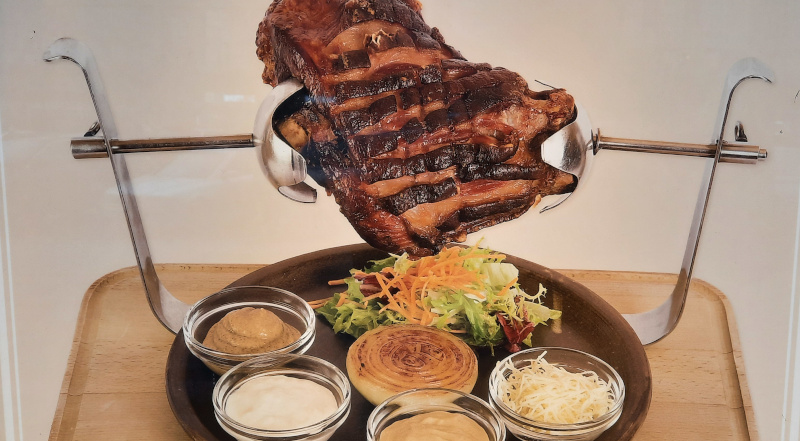 Czech Pork Knuckle served on a skewer with condiments