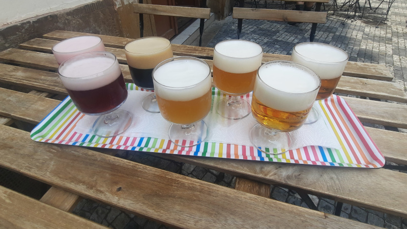 flight of beer on a tray on a wooden table in prague