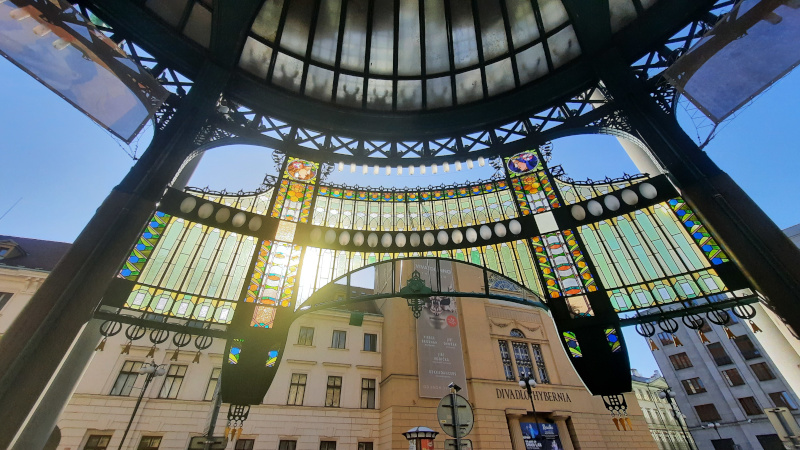 the prague municipal house stained glass entry looking back to a sunrise over the hybernia theatre