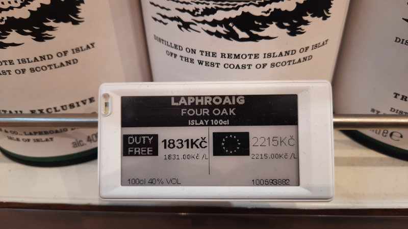 signage at a prague airport duty free shop showing EU and non-EU pricing for a 1L bottle of laphroaig