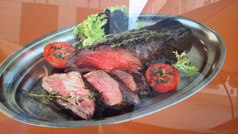 one kilo of beefsteak with grilled tomato on a metal plate