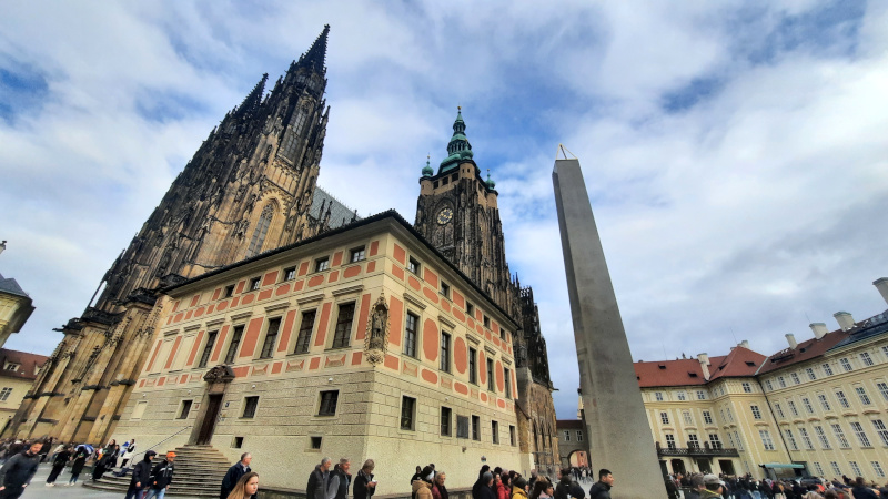 Prague castle obelisk in the third courtyard of the castle with the old deanery and st vitus cathedral