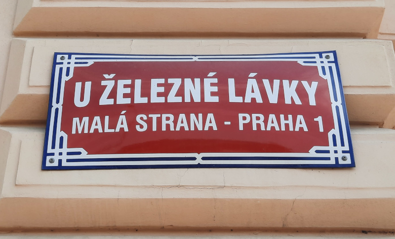 Prague street sign in the lesser town that reads u zelezne lavky which translates as at the place of the iron footbridge