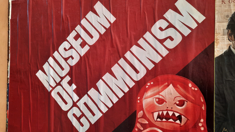 signage for museum of communism in prague where russian doll has sharp teeth